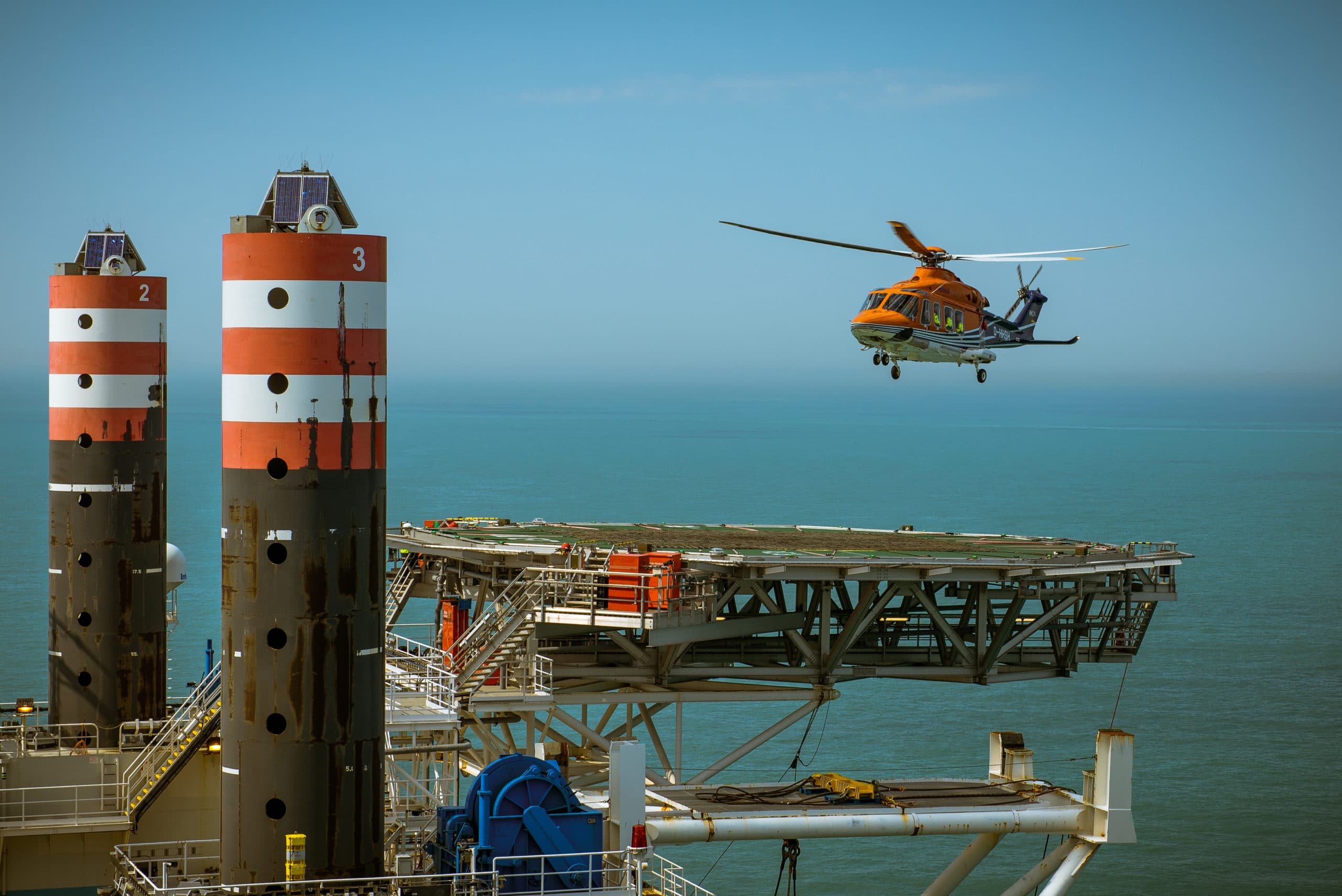 helicopter landt op boorplatform, helder maritiem